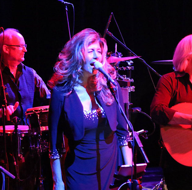 Female vocalist with band on stage